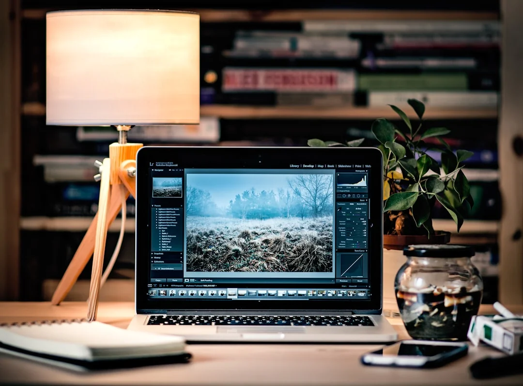 Vue en plongée d’un bureau de travail élégant avec deux écrans, un clavier, une souris et des accessoires contemporains.